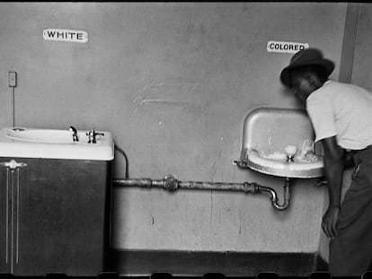 Un hombre bebe en una fuente de agua separada para negros, en Wilmington (Carolina del Norte) en 1950.