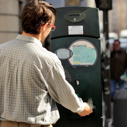 Una persona saca el tique de aparcamiento en el centro de Vitoria.