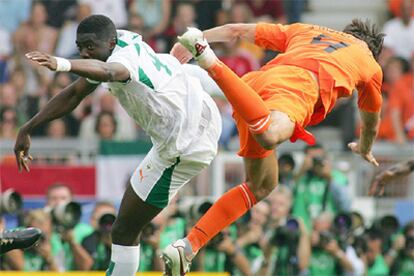 Acrobática pugna por el balón de Meité y Van Nistelrooy.