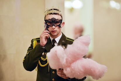 Un cadete militar de Bielorrusia sostiene algodón de azúcar mientras habla por su teléfono móvil durante el Baile de Año Nuevo en el Teatro de Ópera y Ballet Bolshoi, en Minsk. 