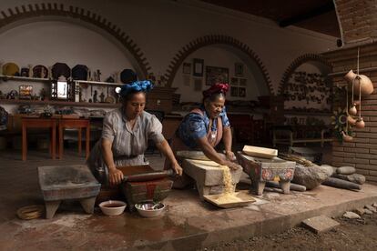 Rosario y Abigail Mendoza (derecha) muelen maíz y chile en el restaurante Tlamanalli, en el Estado de Oaxaca.