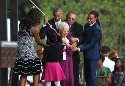 El presidente Barack Obama junto con la primera dama Michelle Obama y Ruth Odom Bonner (c) hacen tocar la campana para inagurar el museo.