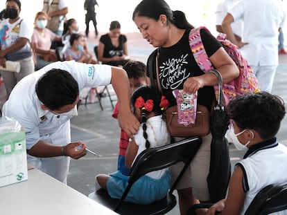 Una niña recibe el refuerzo de la vacuna contra la covid-19, en un colegio en Cancún.