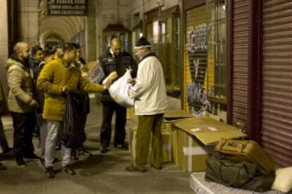 Integrantes de la Iglesia Evangélica Filadelfia de Orcasitas entregan alimentos en la plaza Mayor.