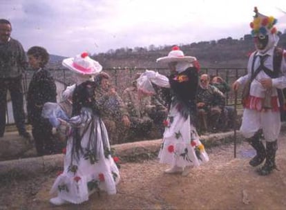 Las mascaritas de Almiruete bailan el sábado de carnaval ante la mirada de un botarga.