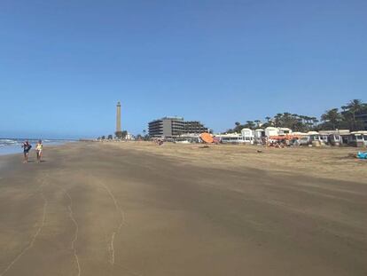 Vista inusual de la playa de Maspalomas con el faro al fondo este lunes, última semana de julio y época en la que todo el litoral canario suele estar abarrotado de turistas y hoy presenta una estampa casi vacía. 