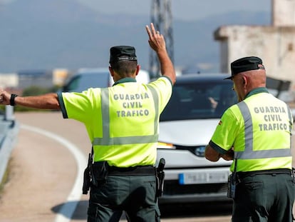 Un agente de la Guardia Civil de Tráfico da el alto a un vehículo durante un control de velocidad. 