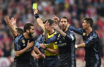 El árbitro de encuentro, el italiano Nicola Rizzoli, muestra tarjeta amarilla al defensa del Real Madrid, Nacho Fernández. 