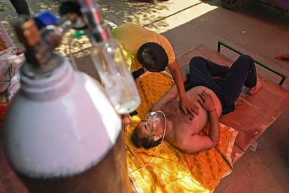 Un paciente respira con la ayuda de oxígeno proporcionado por un gurdwara, un lugar de culto para los sikhs, bajo una tienda de campaña instalada al lado de una carretera de Ghaziabad.