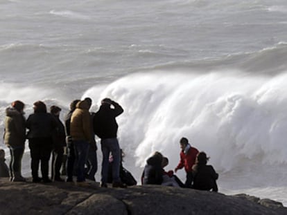 Un grupo de personas observa el fuerte oleaje en la costa de Muxía.