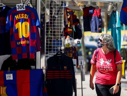 Una persona mira una camiseta de Leo Messi en una tienda cercana a las instalaciones del Camp Nou.