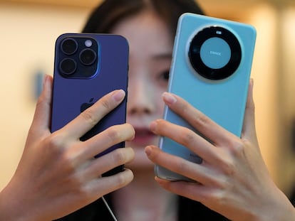 Una mujer mira compara un Huawei Mate 60 Pro con un nuevo iPhone 15 Pro, que salió el 22 de septiembre a la venta en todo el mundo.