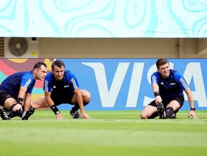 Tres árbitros hacen ejercicios de calentamiento, previo a un partido del Mundial Sub-17 de la FIFA.
