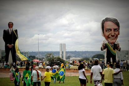 Seguidores del presidente electo de Brasil, Jair Bolsonaro, caminan frente a un muñeco gigante con su figura en la Explanada de los Ministerios, antes de su investidura, en Brasilia.