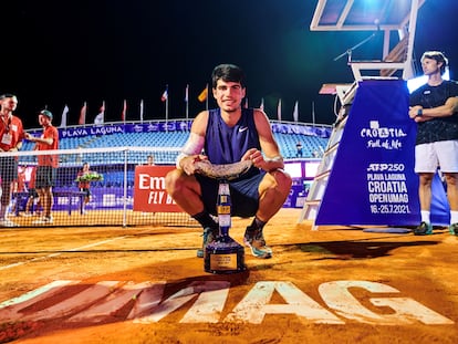 Carlos Alcaraz posa con el trofeo de campeón, el domingo en la pista de Umag, con Juan Carlos Ferrero a la derecha.