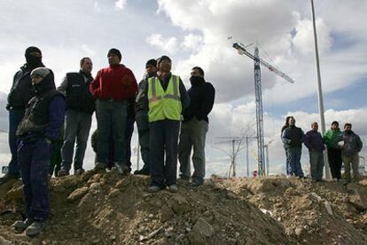 Un grupo de trabajadores observa las labores de rescate en las obras de ampliación de la línea 1 del Metro de Madrid.