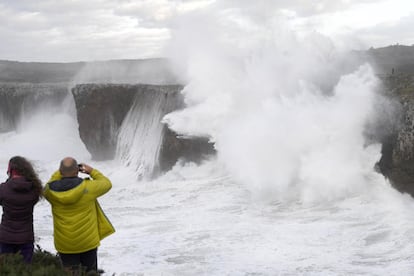 Una pareja observa los bufones de Pria en Asturias durante el temporal, el 13 de diciembre.