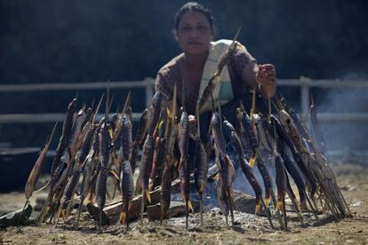 Una mujer indígena del estado de Arunachal Pradesh al noreste de la India asa unos pescados durante las celebraciones del día del Estado en Itanagar, India.