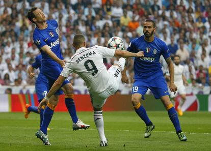 El davanter francès del Reial Madrid Karim Benzemá controlant la pilota davant els defenses de la Juventus de Torí Stephan Lichsteiner i Leonardo Bonucci, durant el partit de tornada de les semifinals de la Lliga de Campions.