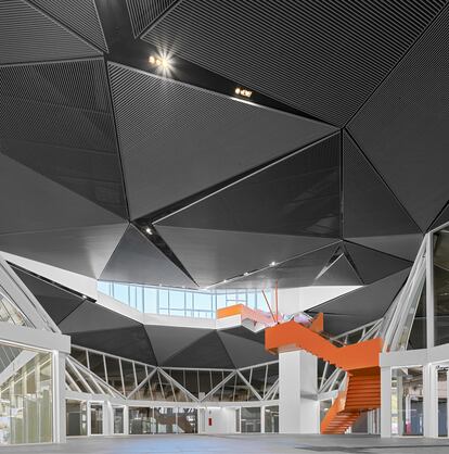 Una escalera con una gran vocación escultórica conecta la sala de espera de la estación con el parque que se sitúa encima.