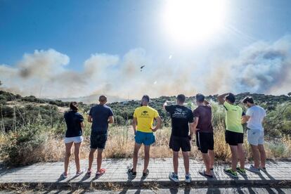 Varios vecinos observan el humo producido por el incendio forestal que se declaró este viernes el paraje denominado Cerro de los Palos de Toledo.