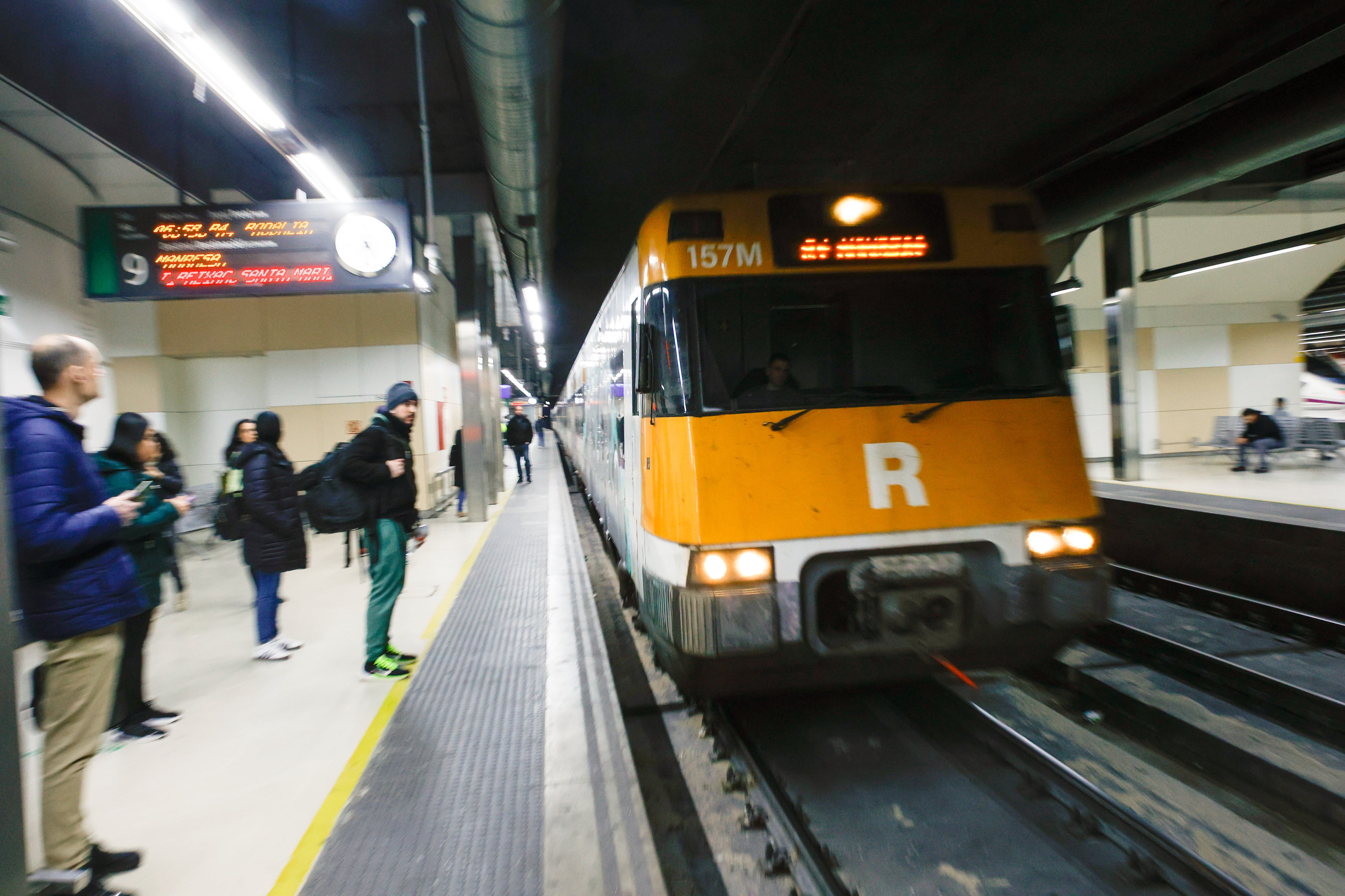 Varios viajeros esperan la llegada de un tren de Rodalies en la estación de Sants en Barcelona, este viernes.