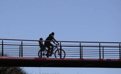 Un padre pasea en bici con su hijo en Vitoria.