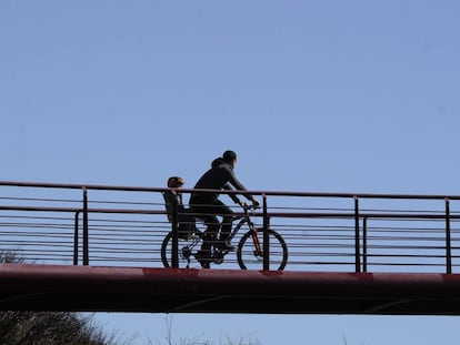 Un padre pasea en bici con su hijo en Vitoria.