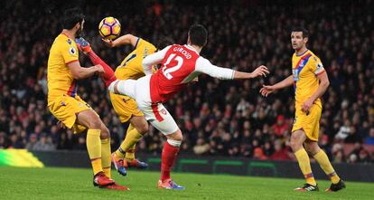 Giroud remata de forma acrobática entre dos defensores.