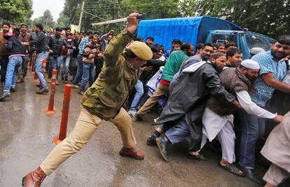 Un policía indio dispersa a manifestantes empleados del Gobierno durante una protesta para exigir sus atrasos pendientes, en Srinagar.