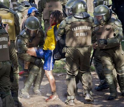 Policiais prendem manifestante em Santiago.