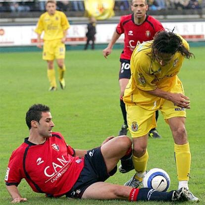 El jugador del Osasuna José Izquierdo se lanza a los pies de José María Moreno esta tarde en El Madrigal.