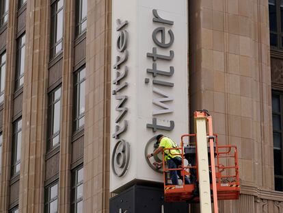 Un trabajador quita el logo de Twitter de la sede de la empresa, en San Francisco, el 24 de julio.