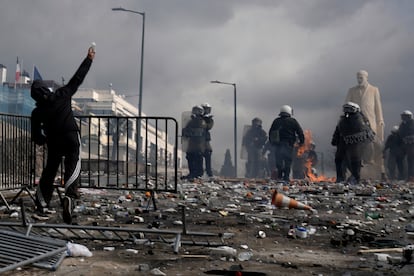 Un manifestante lanza una piedra contra la policía antidisturbios frente al Parlamento en Atenas.