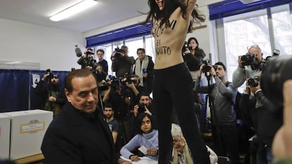 Una mujer, con el lema "Berlusconi, tu tiempo ha expirado" pintado en el torso, protes ante el lider de Forza Italia. (AP Photo/Luca Bruno)