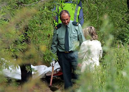 Un guardia civil muestra a la juez la azada con la que se produjo el homicidio.