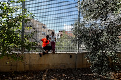 Ruba Ghryib, 10 years old (left), and her sister Haya, 8, look out at the house that Jewish settlers built on the land of this Palestinian family and that has left their home absorbed by the Israeli settlement of Givon Hahadasha.