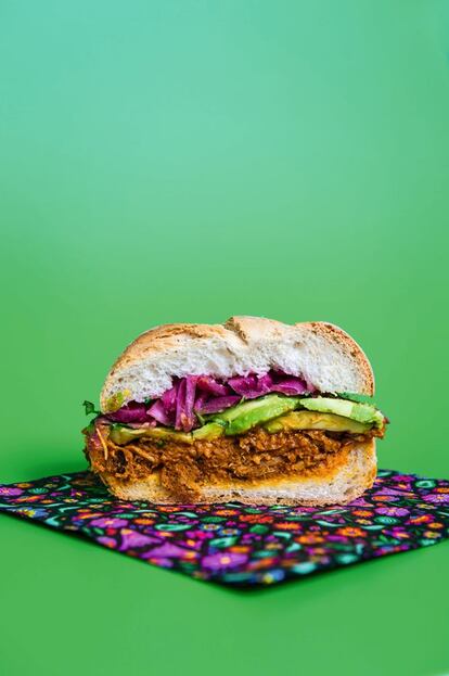 <p><b>Esta sugerencia</b> –también conocida como torta– aúna algunos de los sabores más tradicionales de México. Aunque la cantidad de cochinita supera en mucho la necesaria para un bocadillo, se puede congelar perfectamente, y también comer con tortillas o acompañada de arroz y frijoles negros. Para beber, nada mejor que una cerveza aliñada con zumo de limón, sal y diferentes salsas, conocida como michelada.</p> <p><em>Ingredientes: Un panecillo redondo tipo Viena o de hamburguesa, 150 gramos de cochinita pibil, ½ cebolla roja, 3 cucharadas de zumo de lima, 3 cucharadas de zumo de naranja, ½ aguacate, chile verde (jalapeño o habanero) al gusto (opcional), cilantro picado. Para la cochinita: 1 kilo de magro de cerdo, 50 gramos de pasta de achiote, 100 ml de zumo de naranja, 50 ml de zumo de limón, 50 ml de vinagre de vino blanco, 1 cucharadita de pimienta negra, ¼ de cucharada de canela en polvo, ¼ de cucharada de comino en polvo, 3 dientes de ajo pelados, 1 hoja de laurel, 1/2 cucharadita de sal.</p></em> <p><em>Preparación:</em> Batir todos los ingredientes de la cochinita (menos el magro de cerdo) hasta conseguir una pasta. Volcar sobre el magro cortado en tacos, remover bien y dejar marinar en la nevera 24 horas. Poner papel de plata en una fuente de horno, con sobrante para cubrir el contenido de la fuente. Volcar la carne y la marinada y meter al horno a 170º unas dos horas. Reducir la salsa resultante en un cazo y mezclar con la carne, que se deshará en hebras. Cortar la cebolla en rodajas finas y marinar con el zumo de lima y naranja dos horas. En el bocadillo, poner la cochinita, el aguacate y encima la cebolla con el cilantro picado.</p>