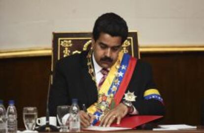 Fotografía cedida por la presidencia de Venezuela muestra al vicepresidente del país, Nicolás Maduro, firmando el acta como presidente encargado. EFE