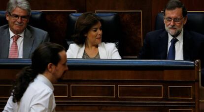 Pablo Iglesias pasa junto al escaño de Mariano Rajoy