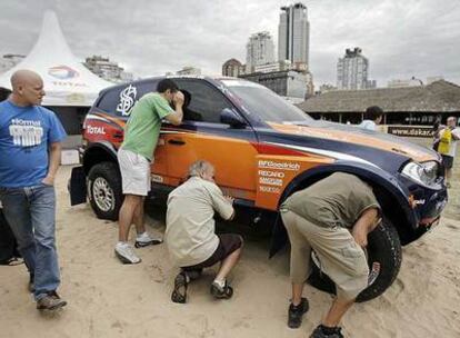 Varios aficionados curiosean uno de los coches del Dakar en Buenos Aires.