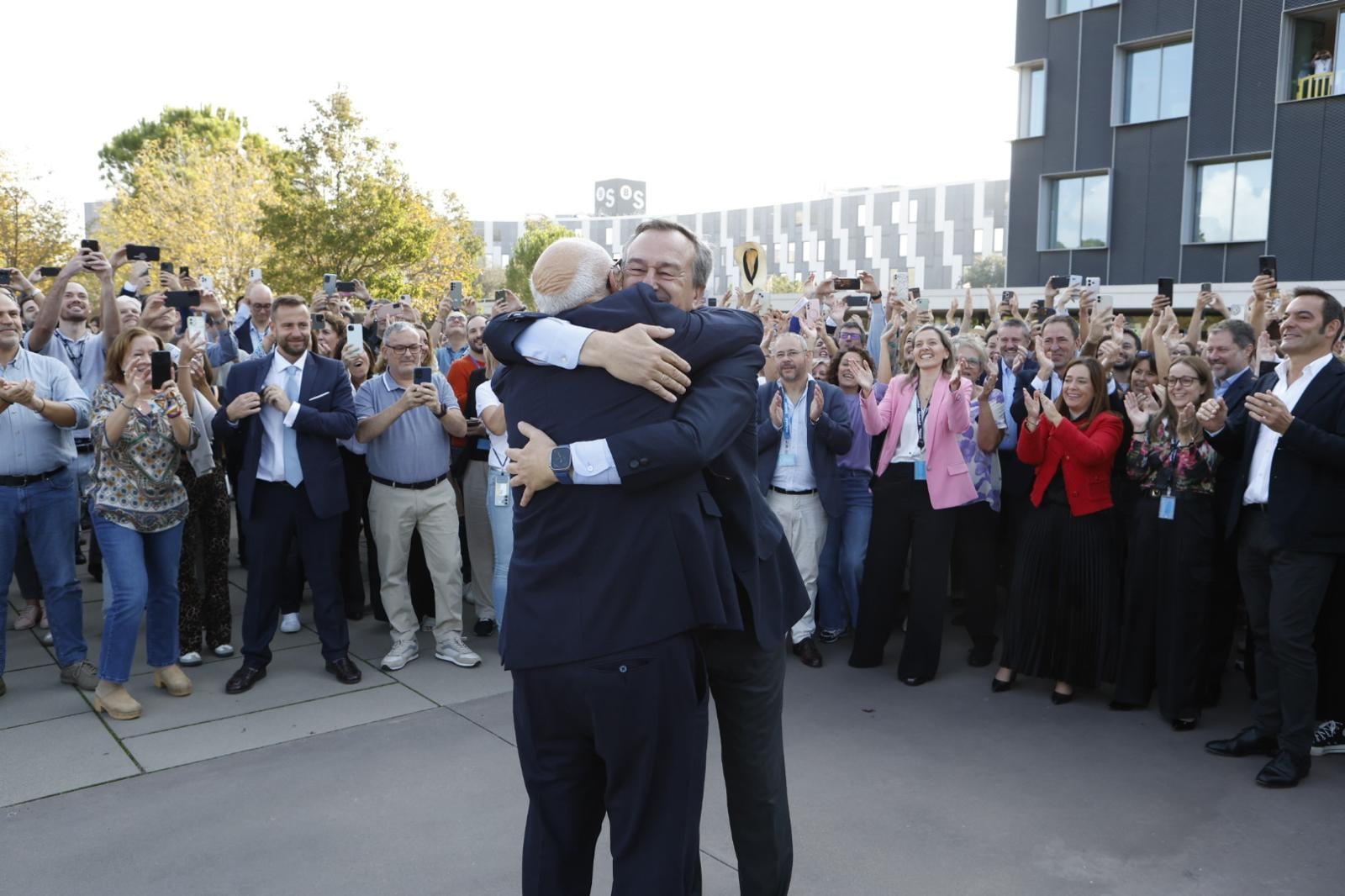El presidente del banco Sabadell, Josep Oliu, y el consejero delegado, César González-Bueno, se abrazan delante de los empleados de la entidad a las puertas de su sede. Foto cedida por la empresa