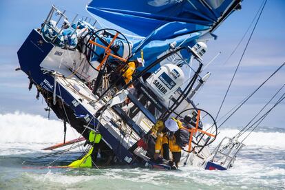 Los restos del navío del equipo Vestas embarrancados durante la noche en el arrecife de coral de Cargados Carajos, a 420 km de Isla Mauricio en el Océano Índico. En la imagen los navegantes intentan recuperar todo lo aprovechable de la nave, velas, cuerdas, combustible. Arrecife Cargados Carajos 30 noviembre de 2014