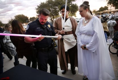 Un policía revisa el sable láser de una aficionada, antes de la proyección de 'Star Wars: El despertar de la Fuerza', en Richardson, en EE UU.