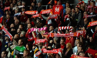 Un grupo de aficionados del Liverpool, con bufandas y camisetas, recuerdan a los fallecidos