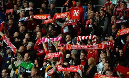 Un grupo de aficionados del Liverpool, con bufandas y camisetas, recuerdan a los fallecidos