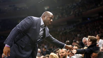 El exjugador de la NBA Magic Johnson saluda a los aficionados antes del partido.