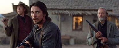 Christian Bale (centro) y Peter Fonda (derecha), en un fotograma de <i>El tren de las 3.10.</i>