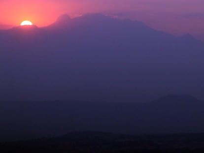El sol saliendo detrás del volcán Iztaccíhuatl al amanecer del 3 de abril de 2022, el primer día del horario de verano, en Ciudad de México.