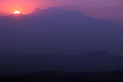 El sol saliendo detrás del volcán Iztaccíhuatl al amanecer del 3 de abril de 2022, el primer día del horario de verano, en Ciudad de México.